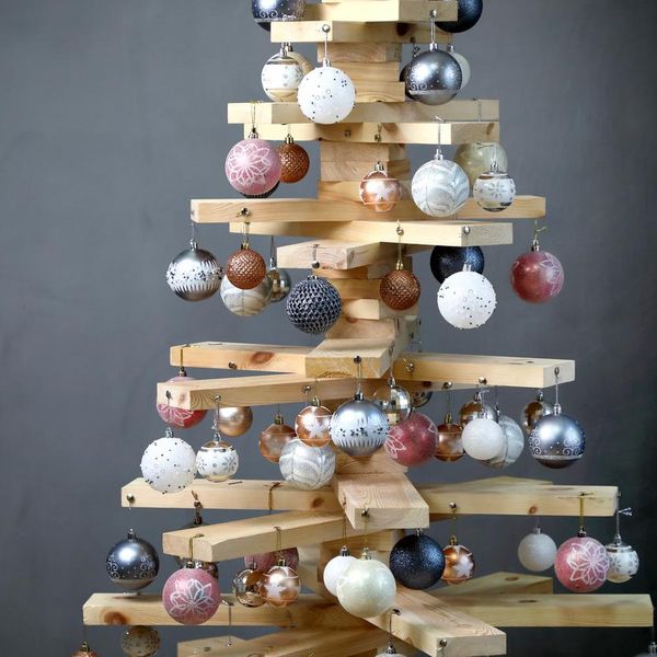 Christmas tree in the new year of wood boards, decorated with balls, on a gray background . horizontally, copy space .