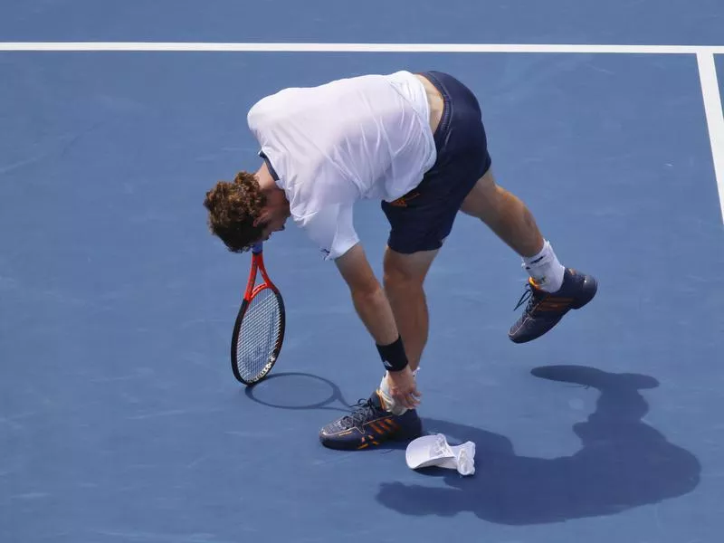 Andy Murray picks up his hat after it fell off while the ball was in play against Tomas Berdych during a 2012 U.S. Open semifinal match in New York.