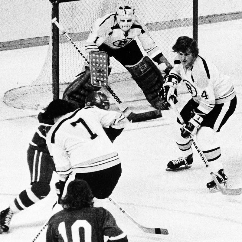 Bobby Orr guards the front of the net as Phil Esposito scrambles