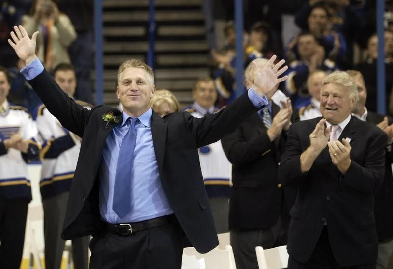 Brett Hull waves to fans as father Bobby Hull applauds