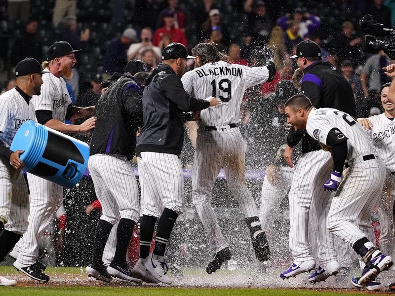 Charlie Blackmon congratulated by Rockies teammates after a walk-off home run
