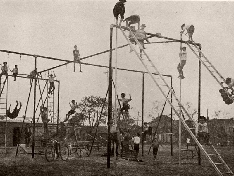 Children climbing on playground equipment in 1900