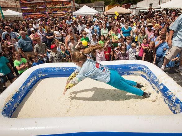 Contestant jumping into a tub of grits