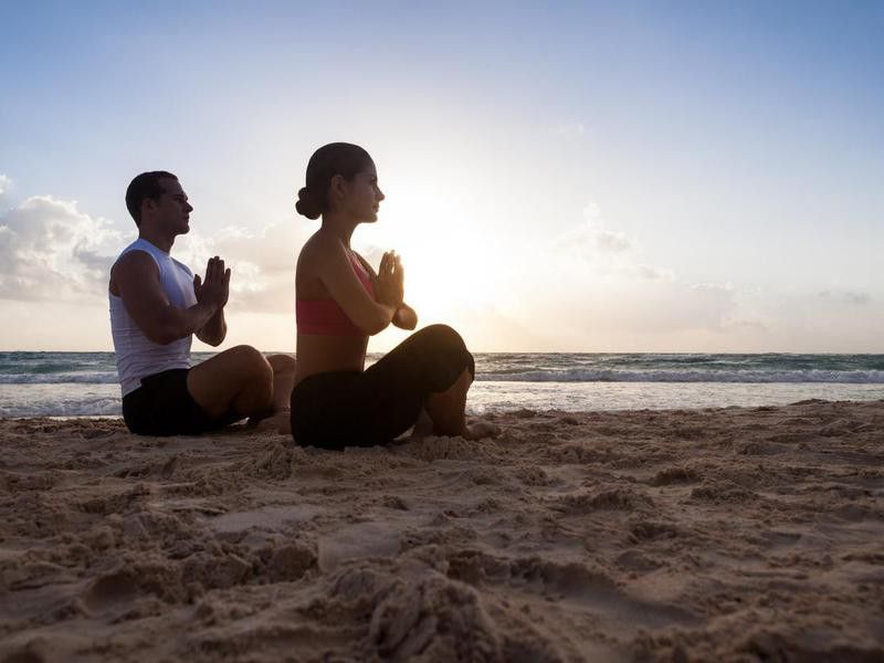 Couple meditating on the beach in Tulum