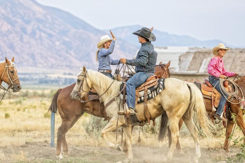 Cowgirl and cowboy congratulate each other while on horseback