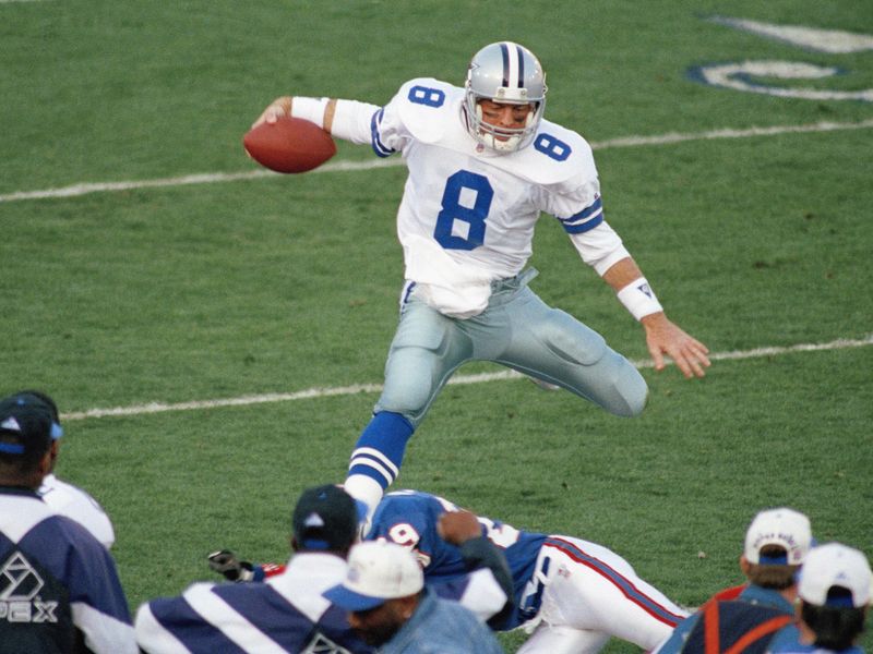 Dallas Cowboys quarterback Troy Aikman goes airborne for a second-quarter gain