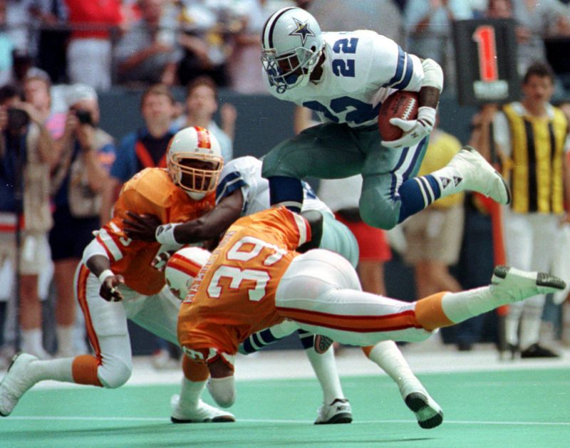 Dallas Cowboys running back Emmitt Smith leaps over Tampa Bay Buccaneers free safety Harry Hamilton