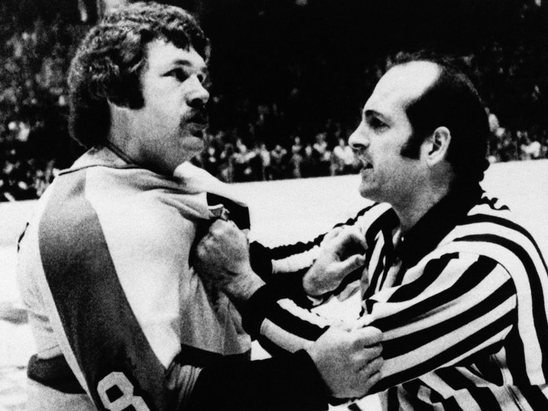 Dave Schultz restrained by linesman