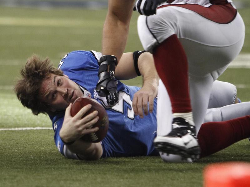 Detroit Lions quarterback Drew Stanton tries to get up after losing helmet while being tackled