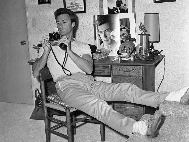 Clint Eastwood, at home in 1965, studies his new camera.