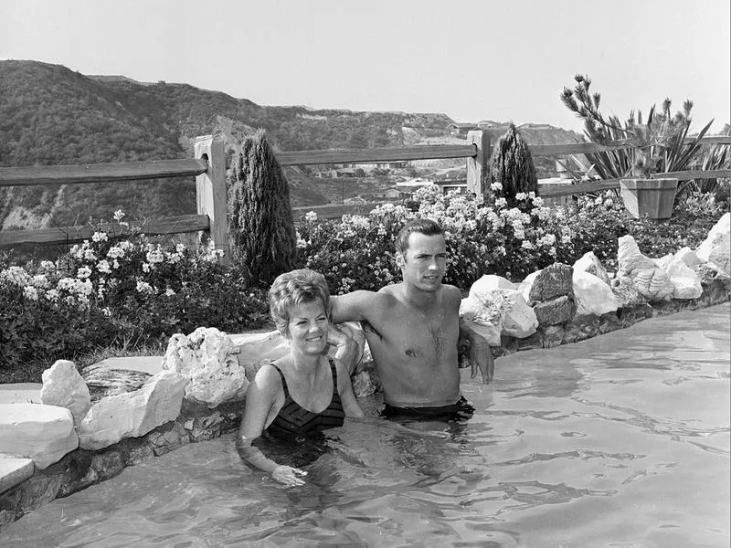 Clint Eastwood and his then-wife, Maggie, relax in their swimming pool at their home in Hollywood Hills in 1962.