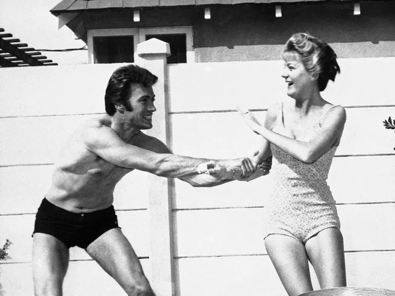 Clint Eastwood frolics with his then-wife Maggie in the swimming pool outside their Hollywood home in 1960.