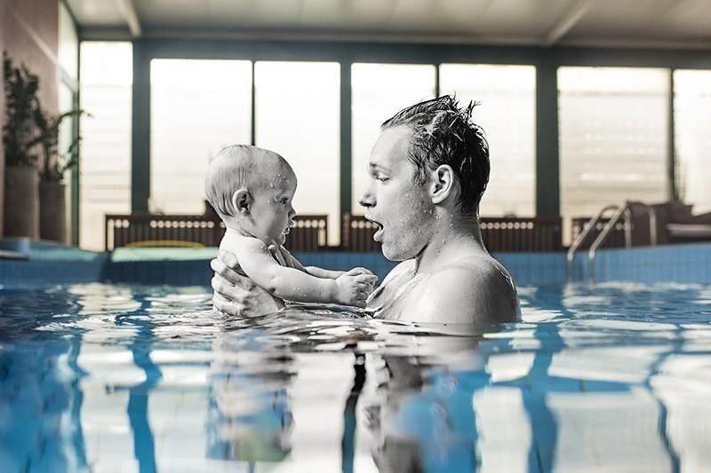 father swimming with baby