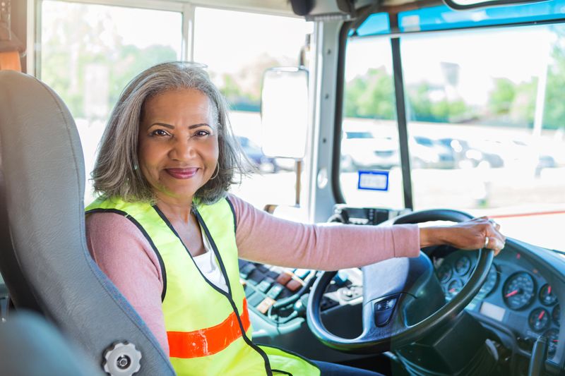 Female bus driver holding wheel