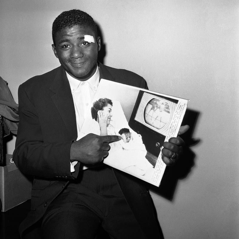 Floyd Patterson points to photo of baby daughter