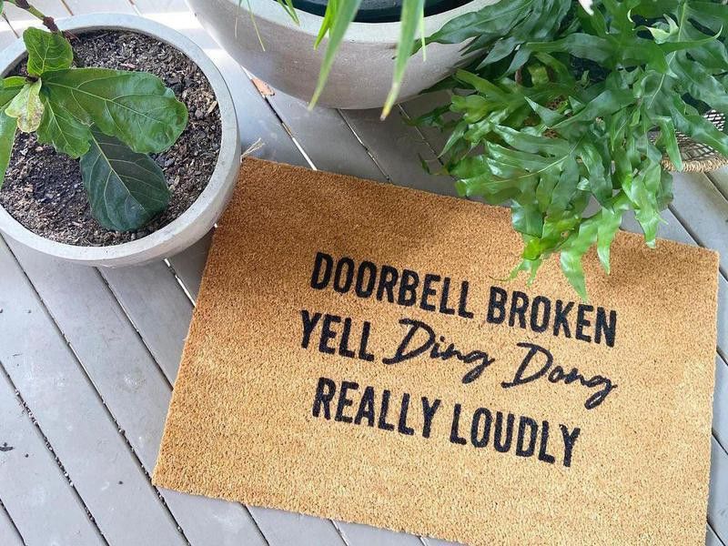 Funny doormat surrounded by houseplants