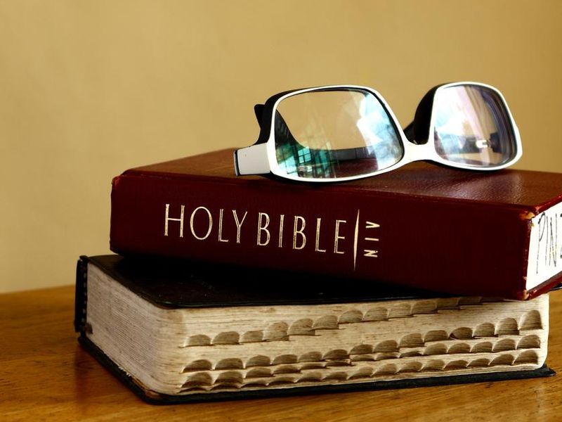 Holy Bibles on a table and eyeglasses