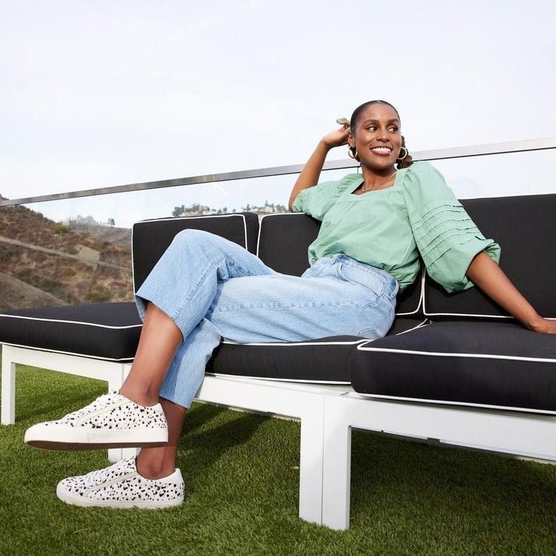 Issa Rae sitting on couch in Madewell clothing