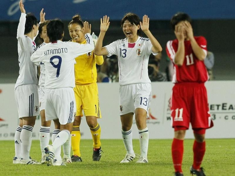 Japanese women soccer players celebrate beating North Korea in 2010