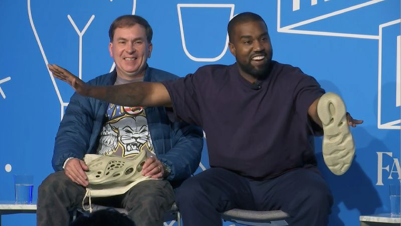 Kanye West holding one of his shoes