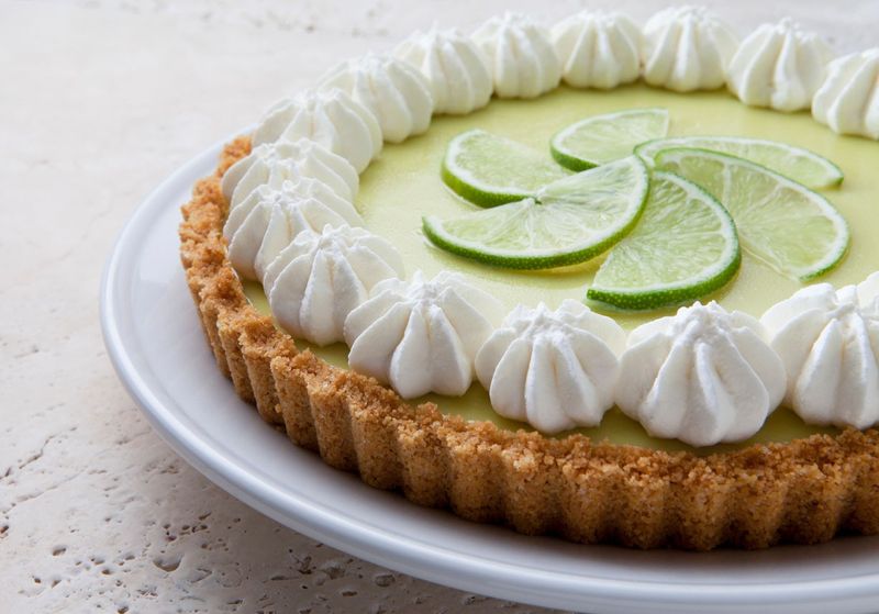 Key Lime Pie With Whipped Cream on a Marble Tabletop.