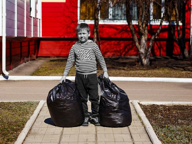 Kid doing chores by taking out trash