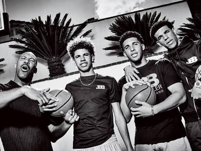 Lavar poses with his sons, Lonzo, LaMelo, and Liangelo on a basketball court