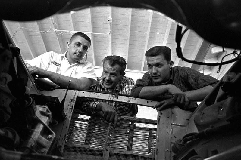 Lee Petty looks into engine well with sons Richard and Maurice