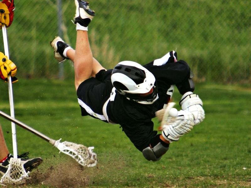 Male Lacrosse Player Flies in Horizontal Dive Capturing Ball