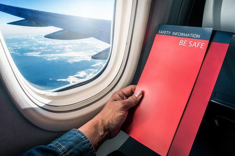 Man reading flight safety instructions