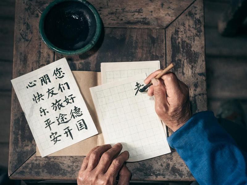 Man writing Chinese calligraphy