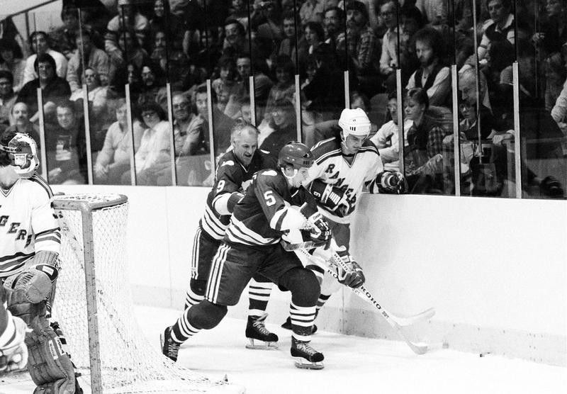 Mark Howe with father Gordie Howe steal puck away from New York Rangers