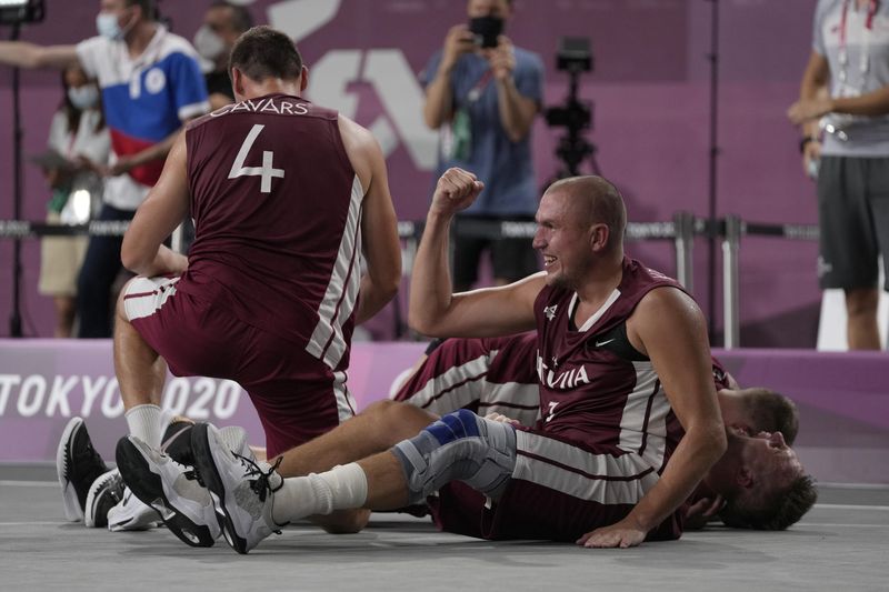 Members of team Latvia celebrate after defeating Russian Olympic Committee to win