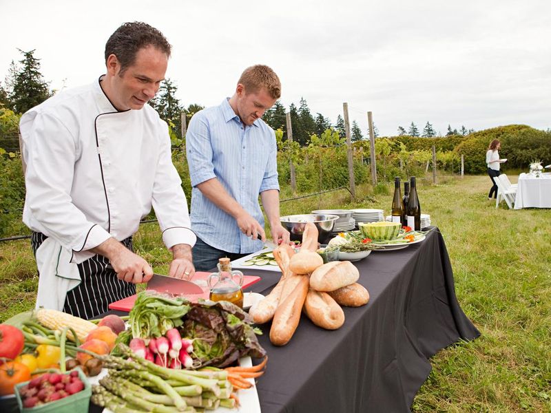 Men preparing food for dinner party in field
