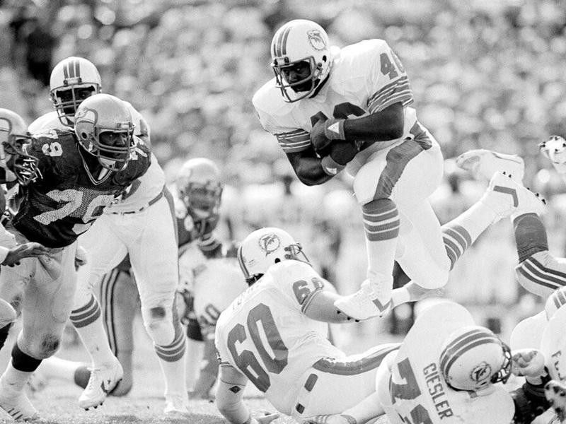 Miami Dolphins fullback Pete Johnson goes over his downed teammates