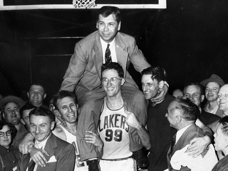 Minneapolis Lakers coach John Kundla hoisted up by players