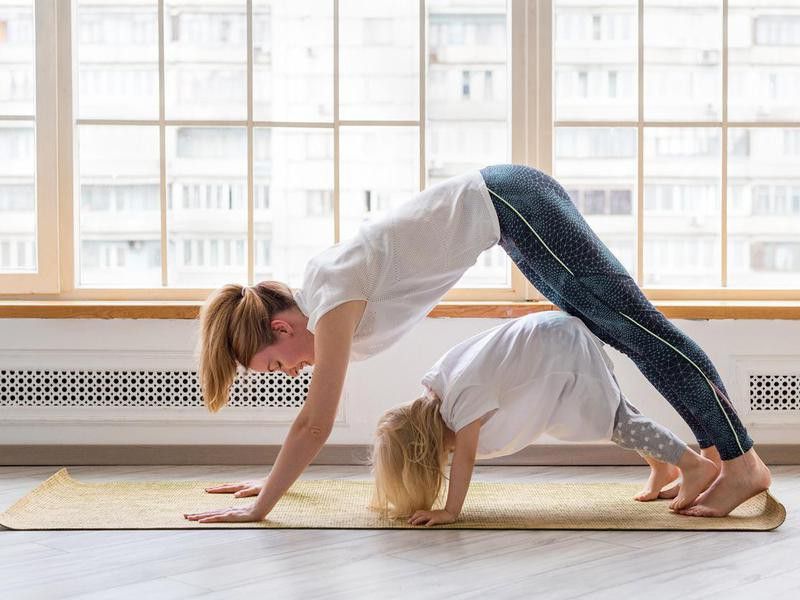 Mother and daughter doing easy yoga poses for kids