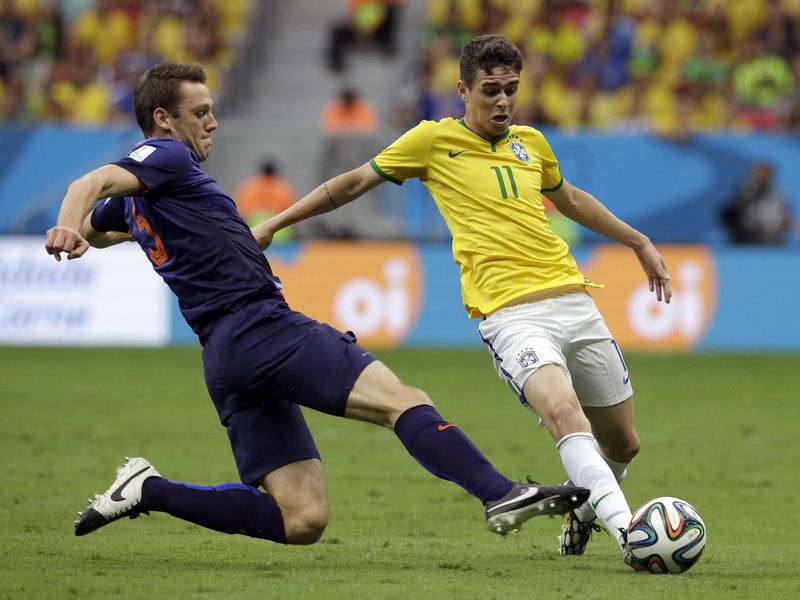 Netherlands' Stefan de Vrij, left, challenges Brazil's Oscar during World Cup third-place soccer match