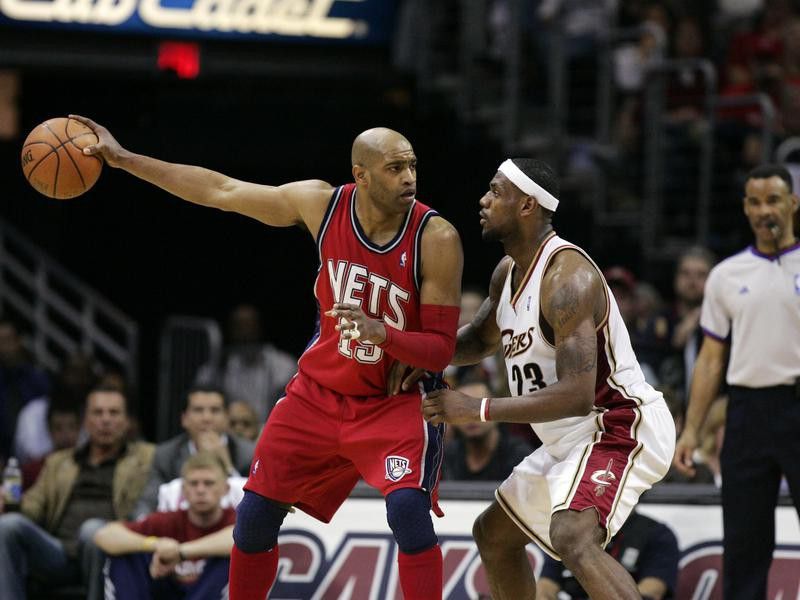 New Jersey Nets' Vince Carter holds ball away from Cleveland Cavaliers' LeBron James
