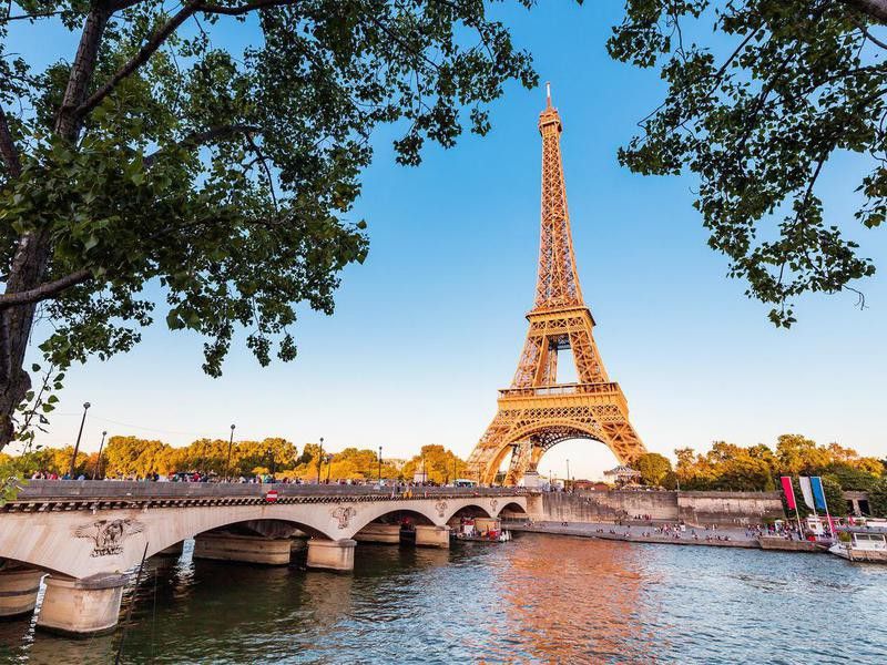 Panoramic view of Eiffel tower and Seine river at sunset.