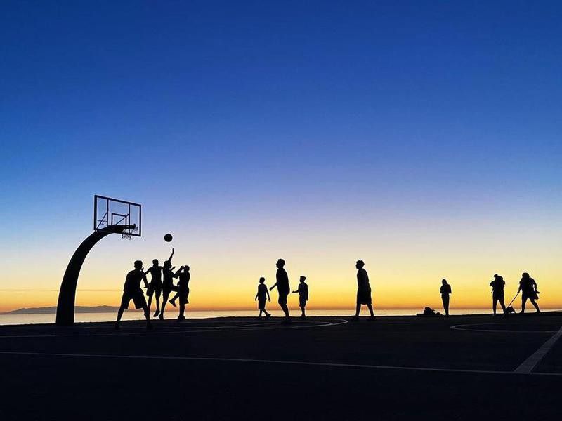 People playing Angels Gate Park Basketball Court at sunset