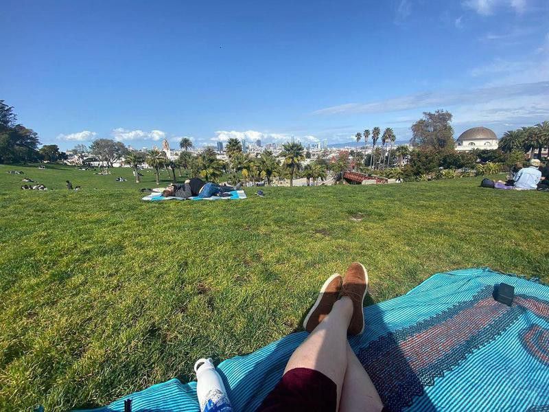 Person sitting on blanket at Dolores Park