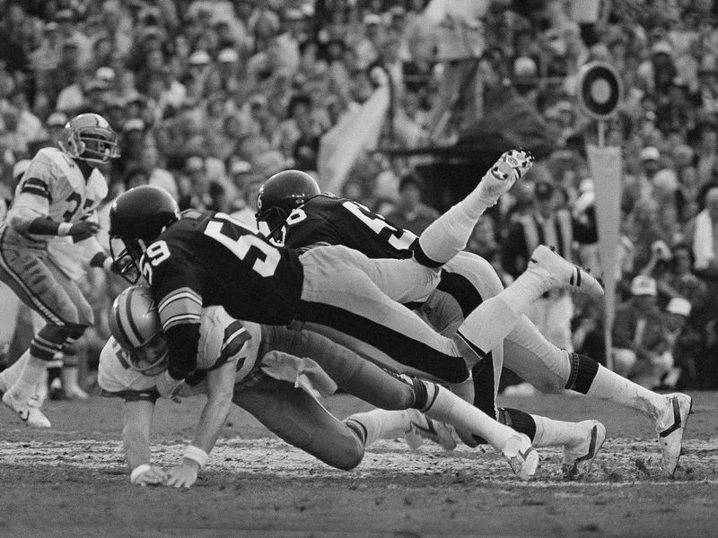 Pittsburgh Steelers linebacker Jack Ham takes down Dallas Cowboys quarterback Roger Staubach