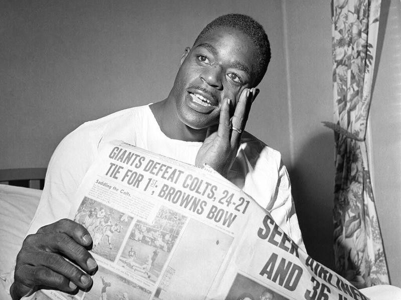 Roosevelt Brown reading the newspaper