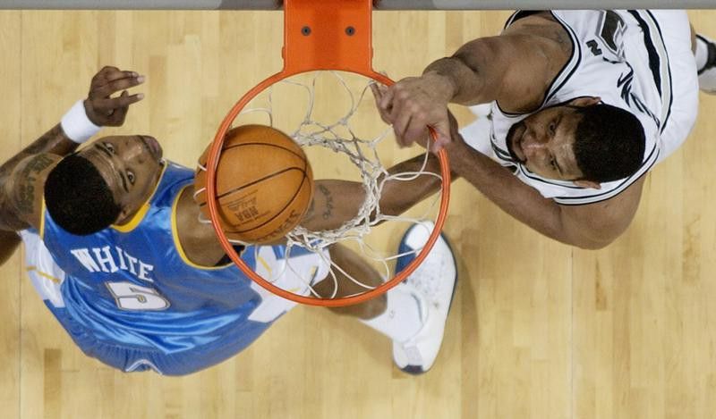 San Antonio Spurs forward Tim Duncan scores over Denver Nuggets defender Rodney White