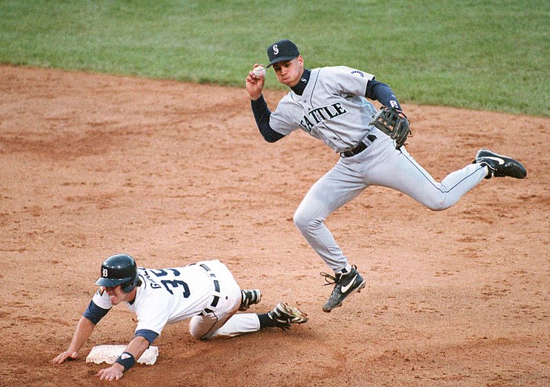 Seattle Mariners shortstop Alex Rodriguez leaps out of way of Detroit Tigers runner Chris Gomez