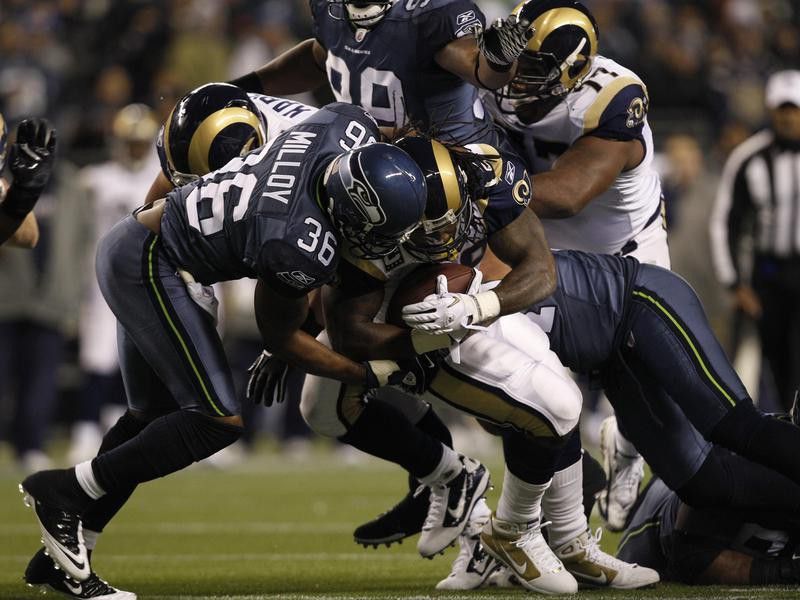 Seattle Seahawks safety Lawyer Milloy tackles St. Louis Rams player in first half