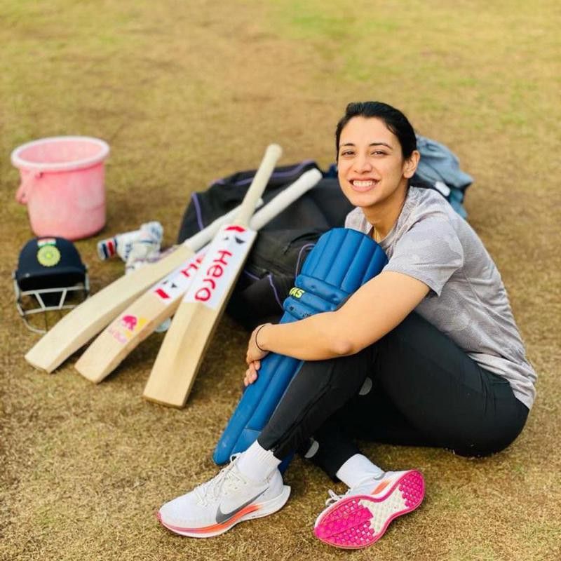 Smriti Mandhana posing with her cricket gear