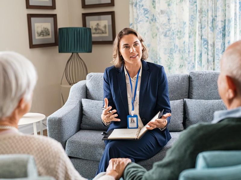 Social worker talking to senior couple at home