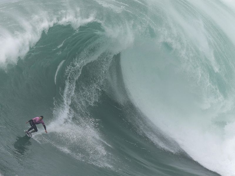 Surfer Eric Rebiere rides wave during Nazare Tow Challenge